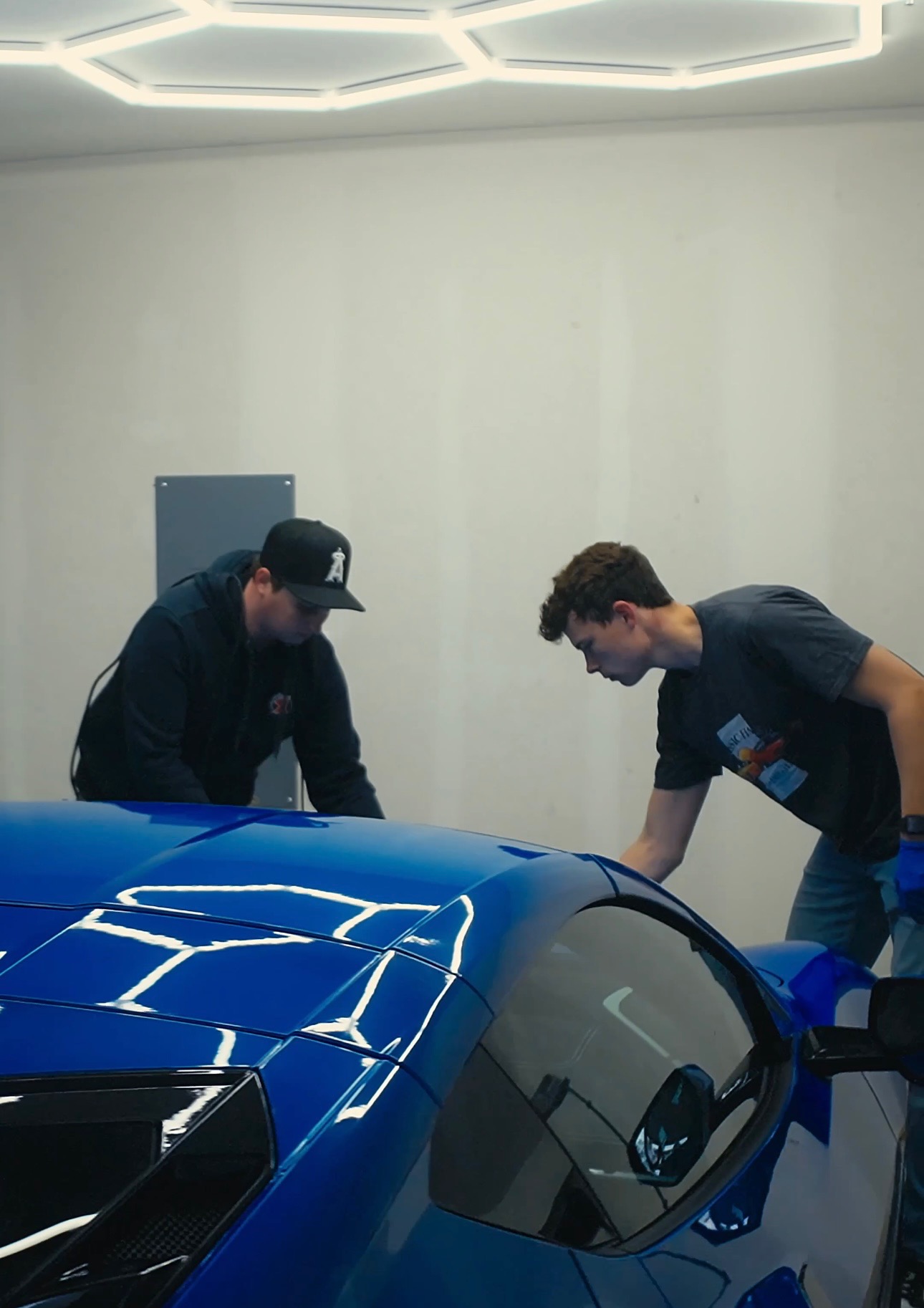 Sawyer and Smalls detailing a blue sports car